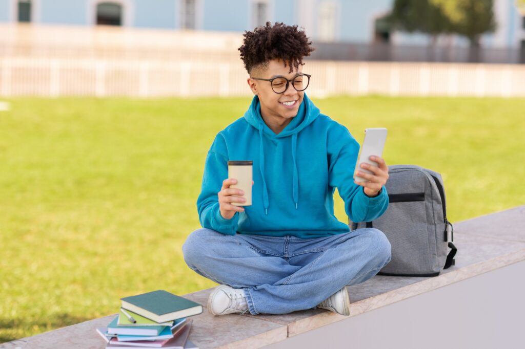 Student comparing coffee cup with smartphone