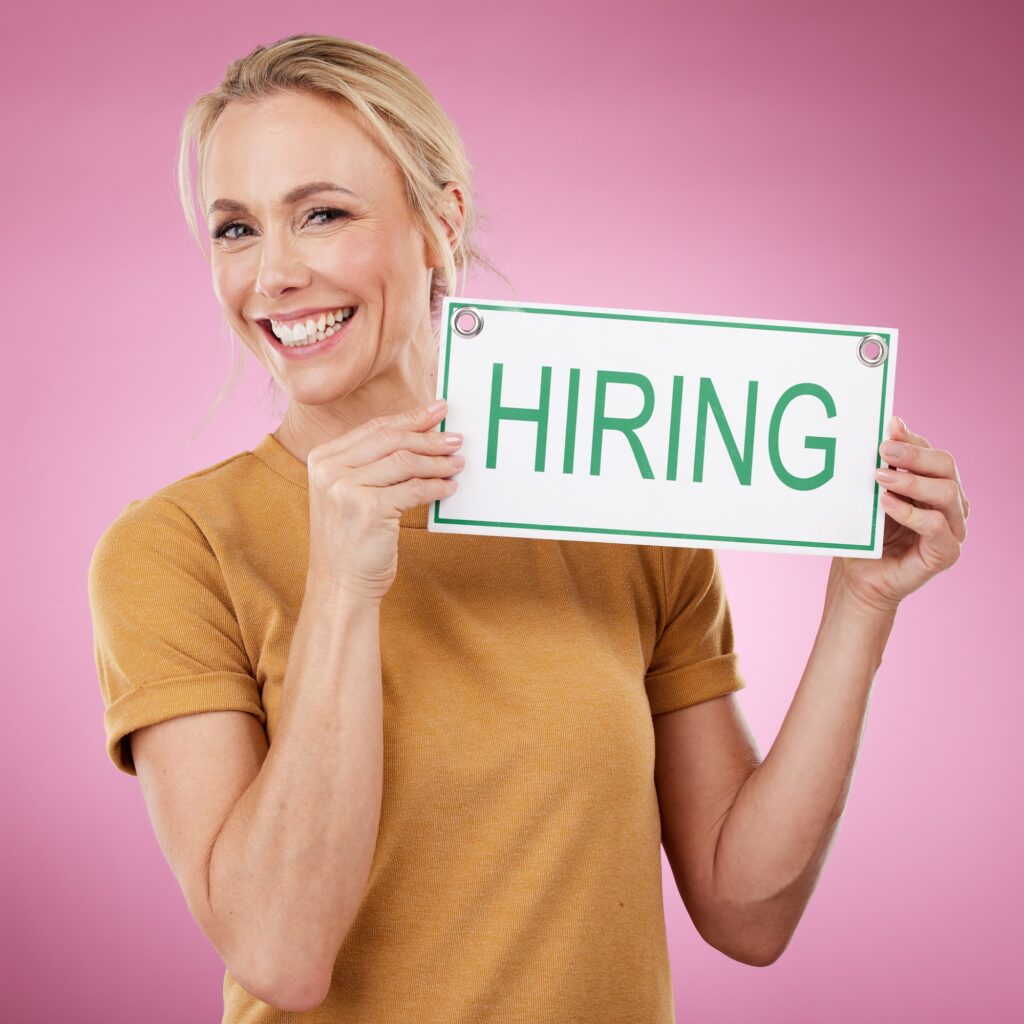 Hiring, sign and portrait of a woman for recruitment, job search and advertising opportunity. Smile