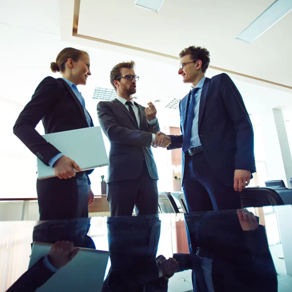business-partners-shaking-hands-meeting-hall-scaled.webp